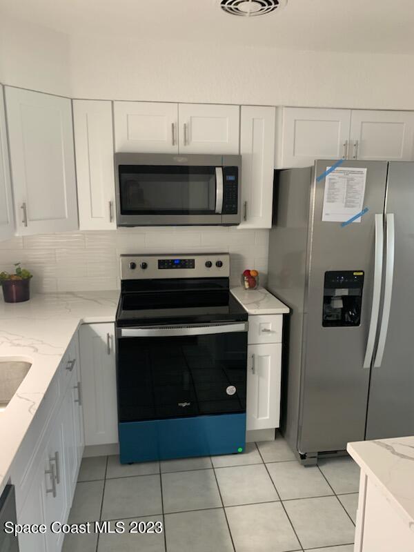 201 Orchid Boulevard Melbourne, FL 32901 - Photo 34 of 36 a kitchen with a stove and a refrigerator
