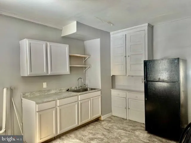 a kitchen with a refrigerator sink and cabinets