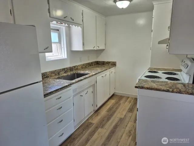 a kitchen with granite countertop cabinets stainless steel appliances and a sink
