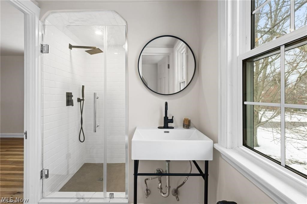 3145 Huntington Road Shaker Heights, OH 44120 - Photo 19 of 28 Modern bathroom featuring a glass-enclosed shower with white subway tile, rain showerhead, and matte black fixtures