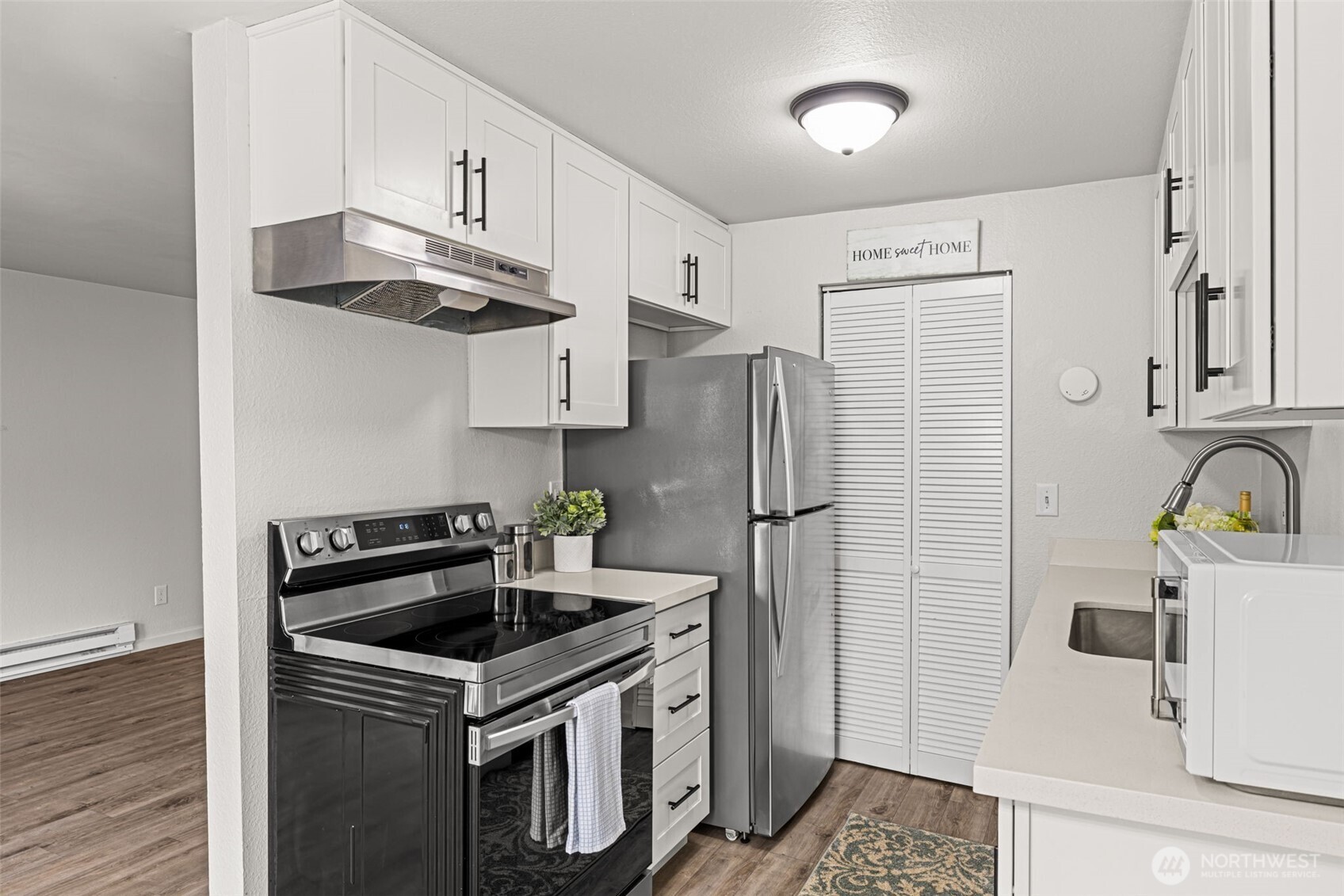 15210 Macadam Road South, Unit D211 Tukwila, WA 98188 - Photo 17 of 26 a kitchen with stainless steel appliances a sink a stove a refrigerator and cabinets