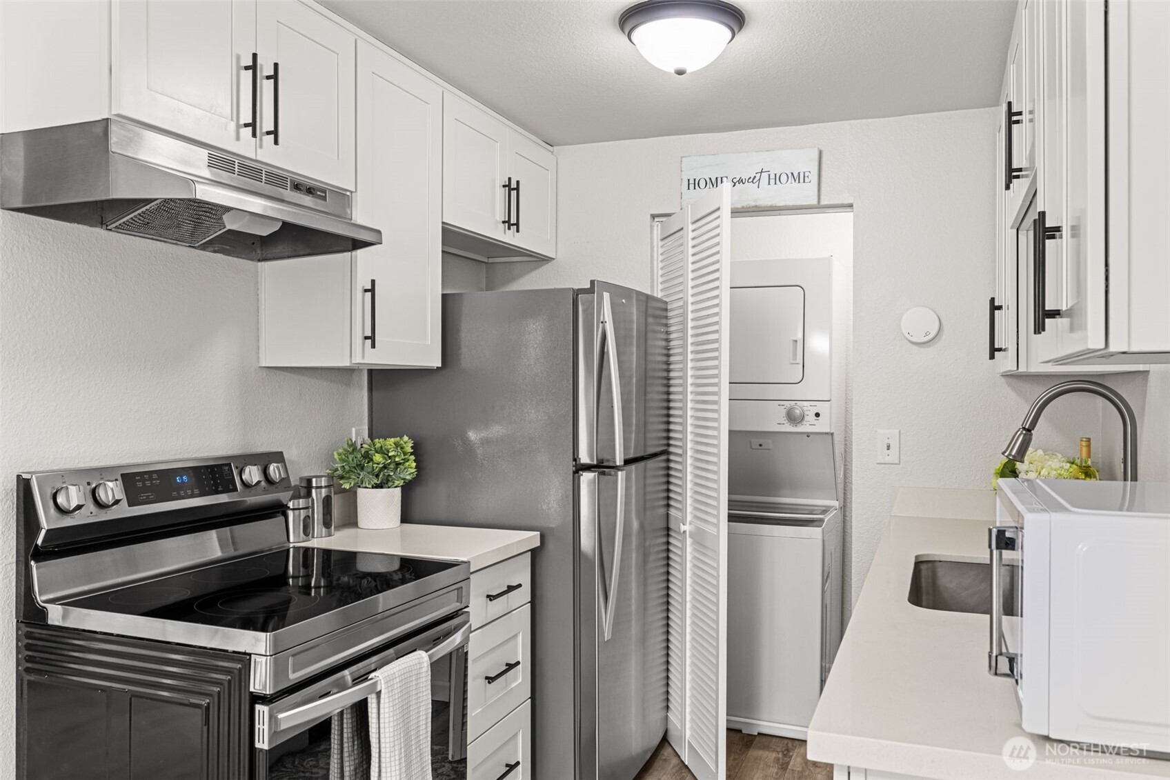 15210 Macadam Road South, Unit D211 Tukwila, WA 98188 - Photo 18 of 26 a kitchen with stainless steel appliances a stove a refrigerator and a sink