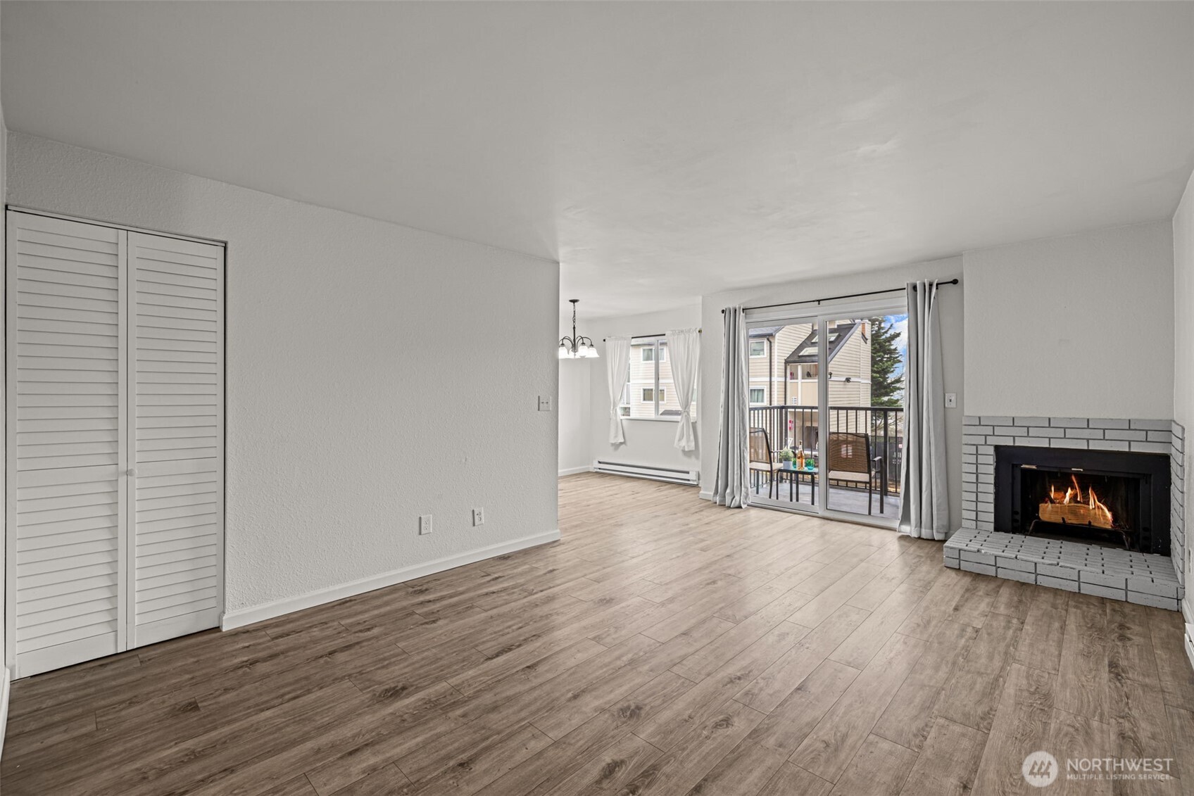 15210 Macadam Road South, Unit D211 Tukwila, WA 98188 - Photo 3 of 26 an empty room with wooden floor fireplace and windows
