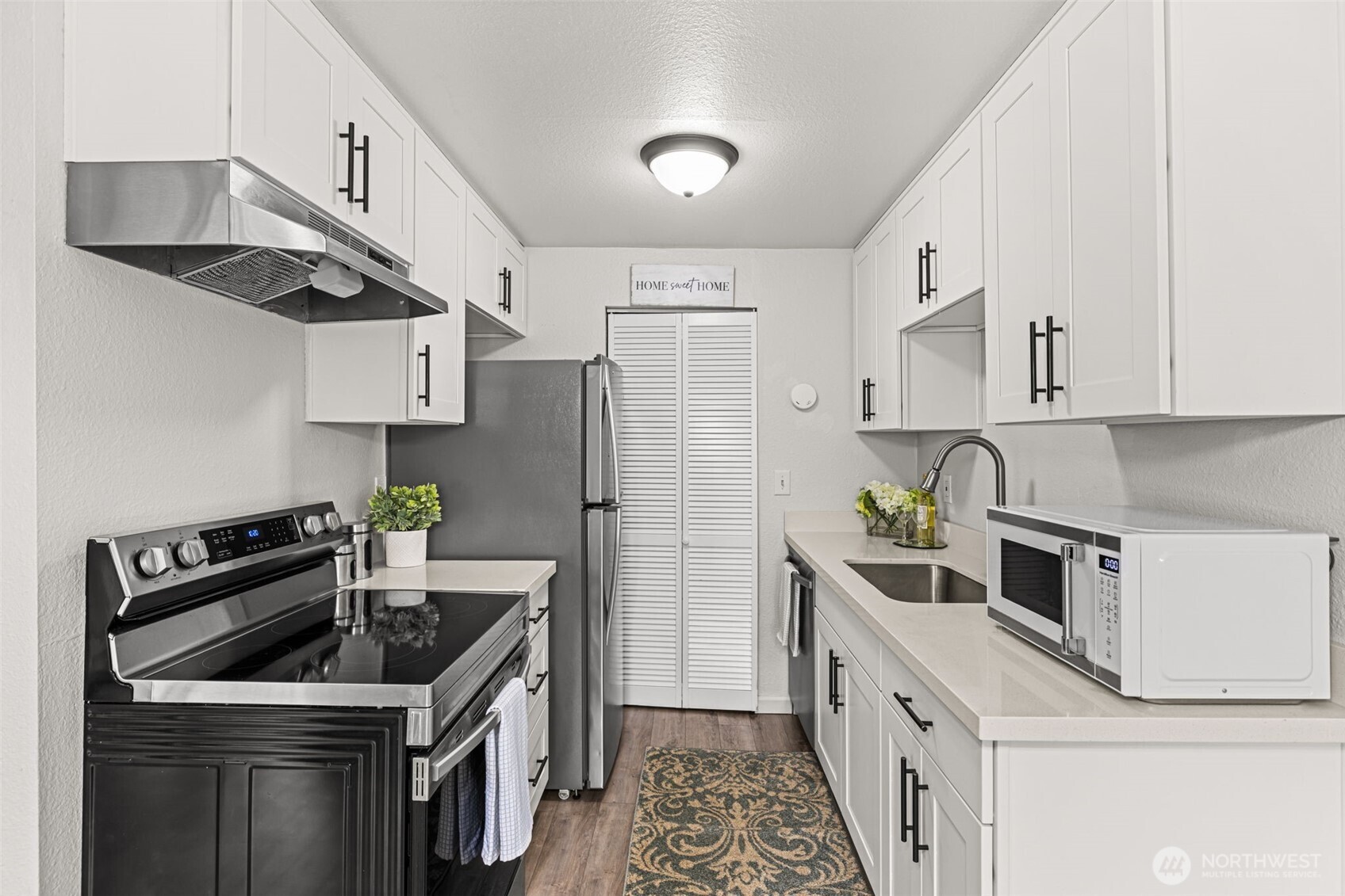 15210 Macadam Road South, Unit D211 Tukwila, WA 98188 - Photo 5 of 26 a kitchen with stainless steel appliances a sink stove and refrigerator