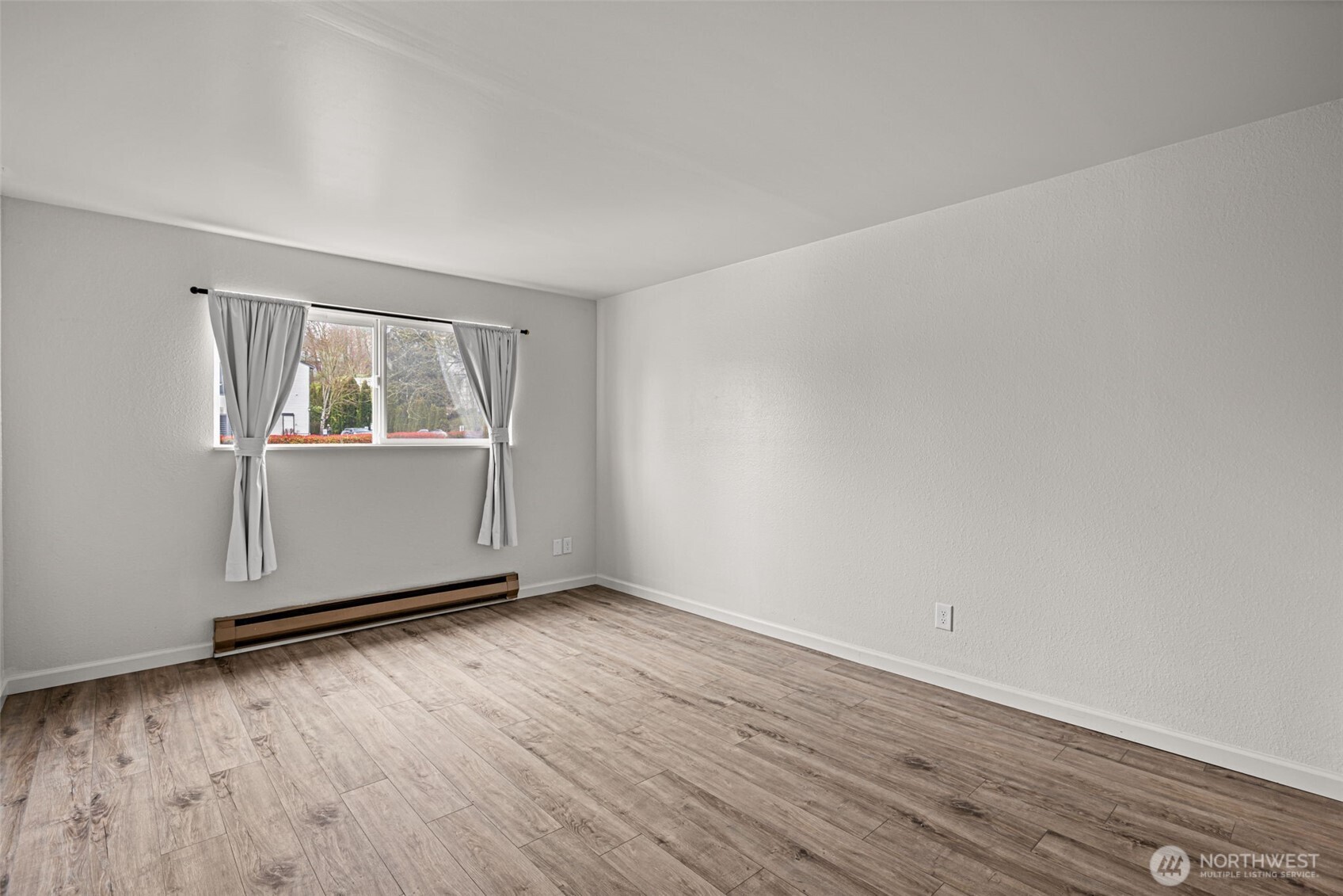 15210 Macadam Road South, Unit D211 Tukwila, WA 98188 - Photo 10 of 26 an empty room with wooden floor and windows
