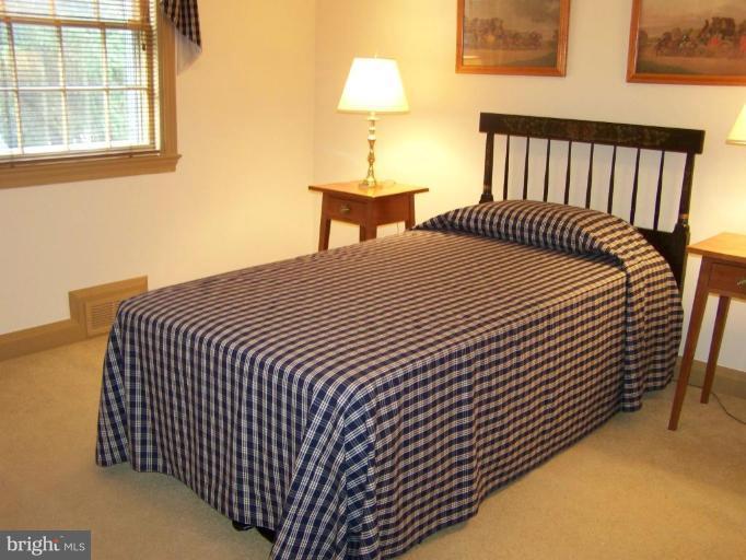 607 Coventry Road Towson, MD 21286 - Photo 14 of 19 a bedroom with a bed and a lamp