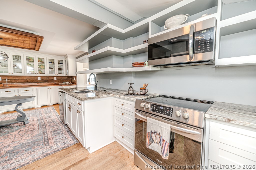 509 Carthage Street Cameron, NC 28326 - Photo 24 of 43 a kitchen with stainless steel appliances granite countertop a stove and a sink