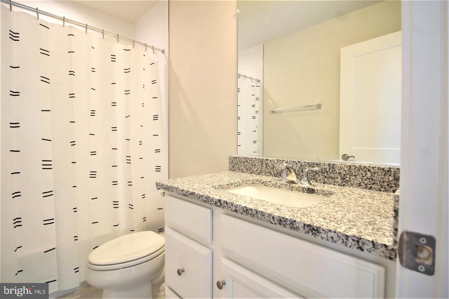 2471 Liberty Loop Herndon, VA 20171 - Photo 25 of 35 a bathroom with a granite countertop sink a toilet and a mirror