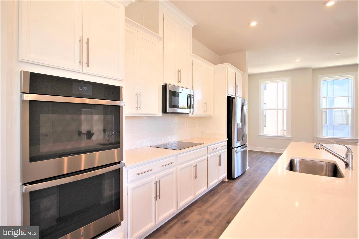 2471 Liberty Loop Herndon, VA 20171 - Photo 10 of 35 a kitchen with stainless steel appliances white cabinets and a stove top oven