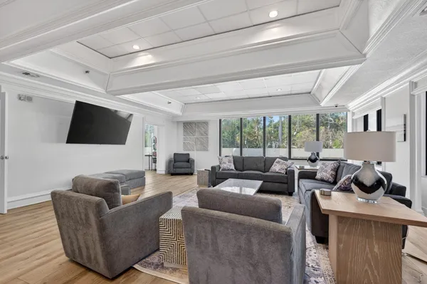 a living room with furniture a table gym equipment and a large window