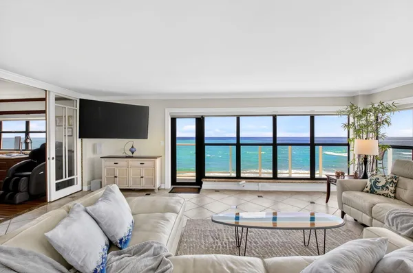 a living room with furniture large windows and a flat screen tv