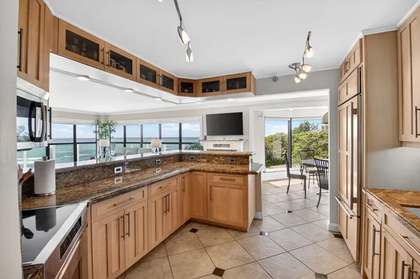 a kitchen with stainless steel appliances granite countertop a sink and a refrigerator