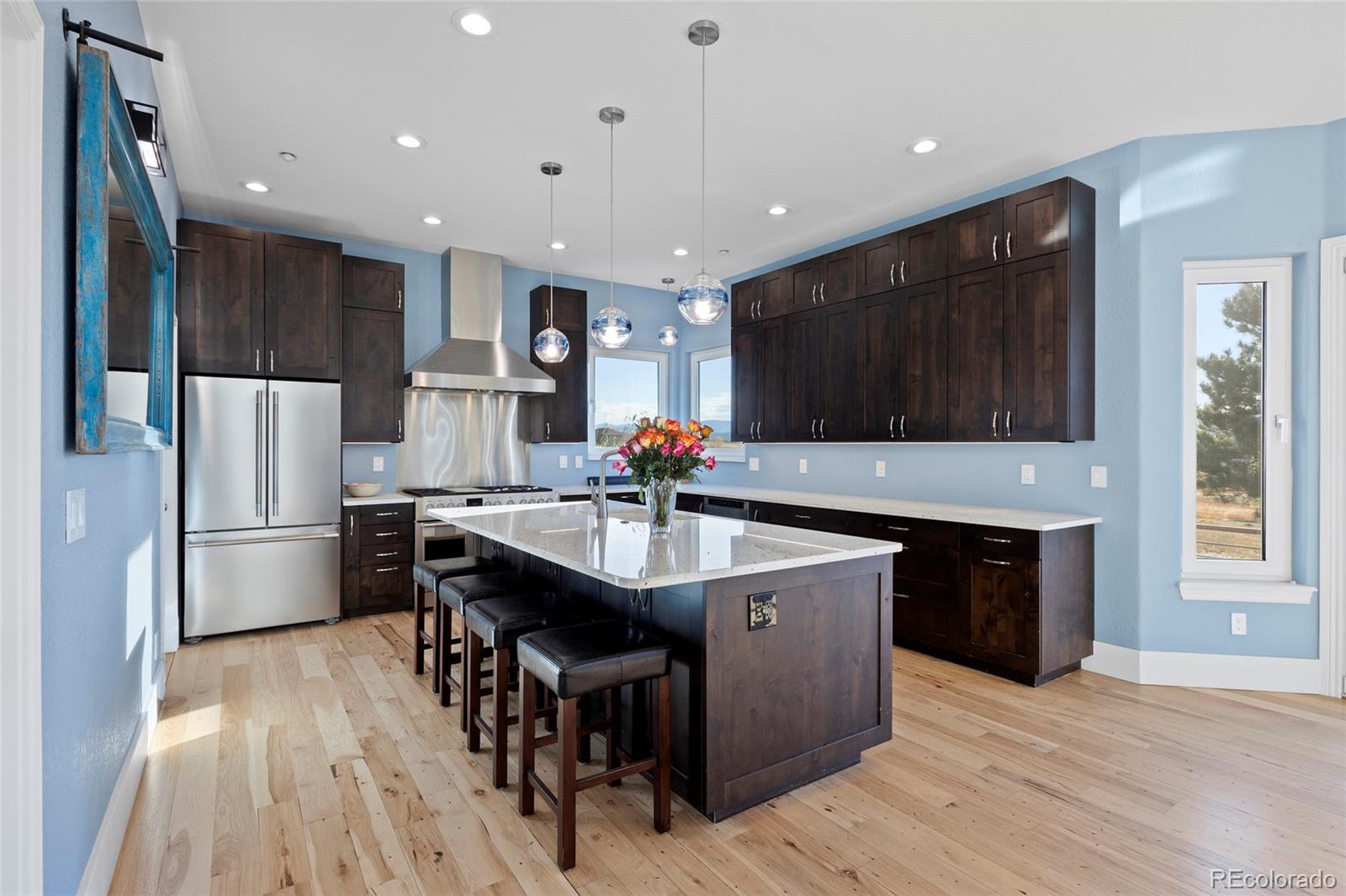 3532 Bell Mountain Drive Castle Rock, CO 80104 - Photo 11 of 50 a kitchen with stainless steel appliances granite countertop a table chairs refrigerator and sink
