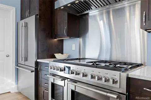 a kitchen with granite countertop a stove and a refrigerator