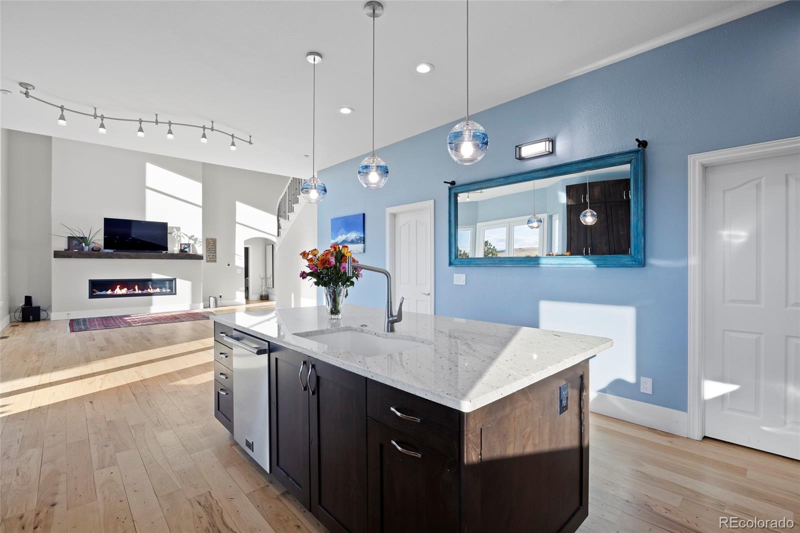 3532 Bell Mountain Drive Castle Rock, CO 80104 - Photo 15 of 50 a kitchen with a center island wooden floor appliances and a view of living room
