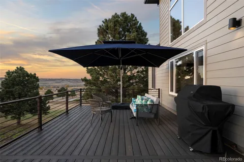 a view of a roof deck with dining table and chairs with wooden floor