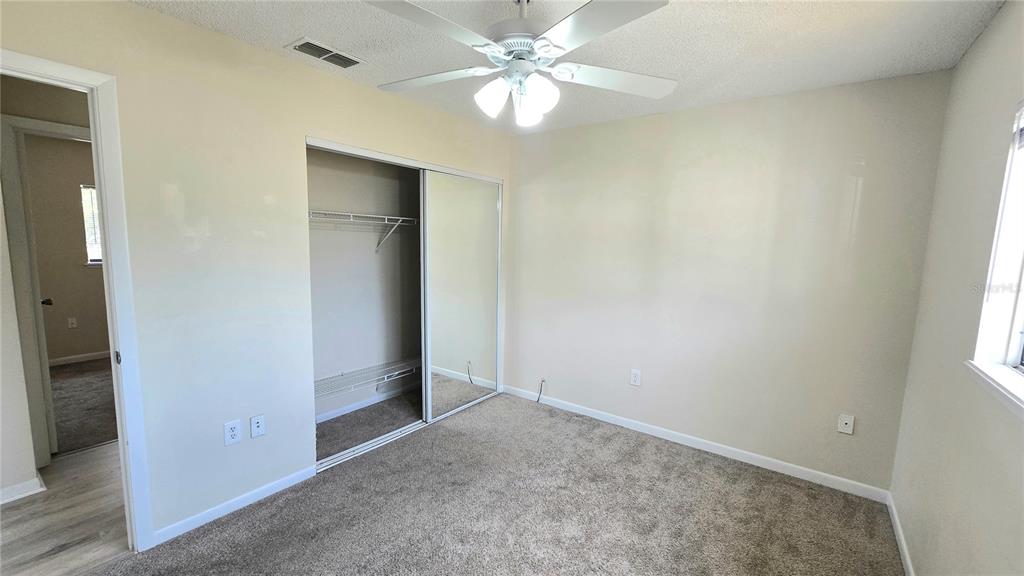 11239 Southwest 77th Court Ocala, FL 34476 - Photo 13 of 22 an empty room with a ceiling fan and a bathroom