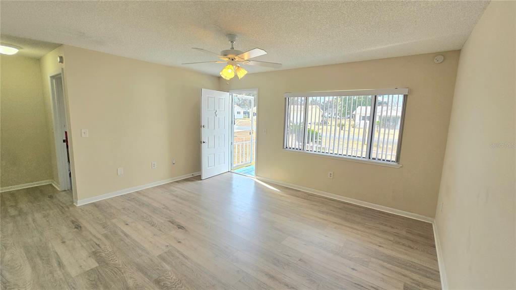 11239 Southwest 77th Court Ocala, FL 34476 - Photo 3 of 22 a view of an empty room with wooden floor and a window