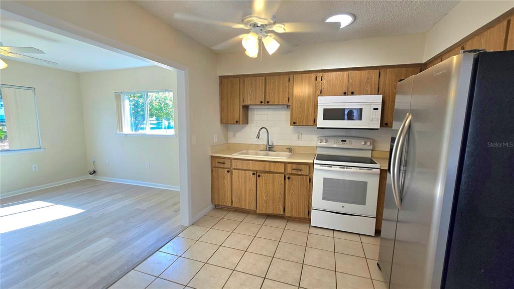 11239 Southwest 77th Court Ocala, FL 34476 - Photo 5 of 22 a kitchen with granite countertop a refrigerator and a sink