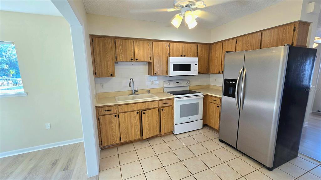 11239 Southwest 77th Court Ocala, FL 34476 - Photo 6 of 22 a kitchen with a refrigerator sink and microwave