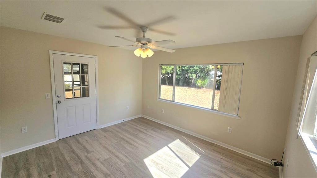 11239 Southwest 77th Court Ocala, FL 34476 - Photo 9 of 22 wooden floor in an empty room with a window