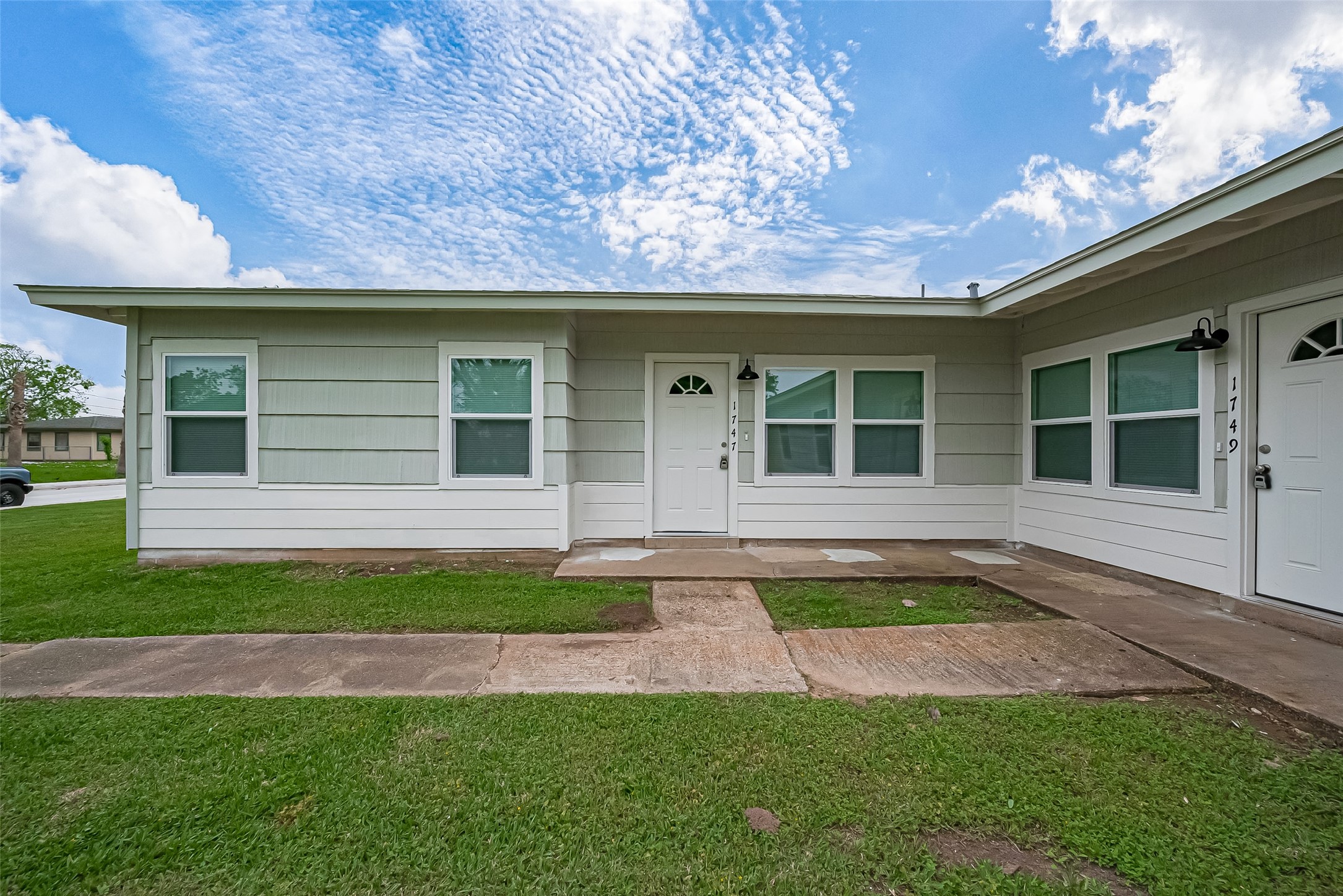 1739-17 West 5th Street Freeport, TX 77541 - Photo 1 of 26 a front view of a house with a yard and garage