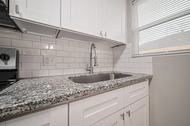 a bathroom with a granite countertop sink and vanity