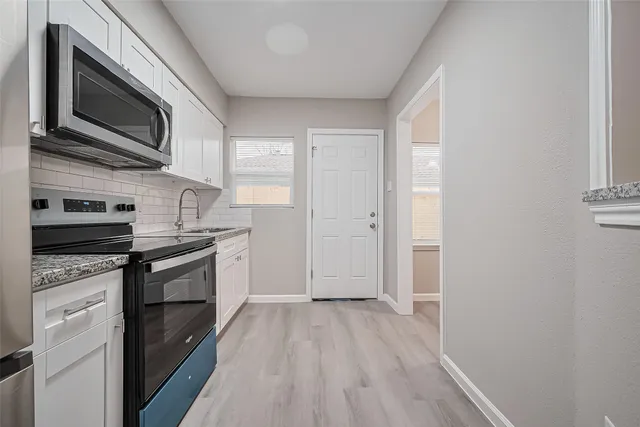 a kitchen with stainless steel appliances granite countertop a stove microwave and sink