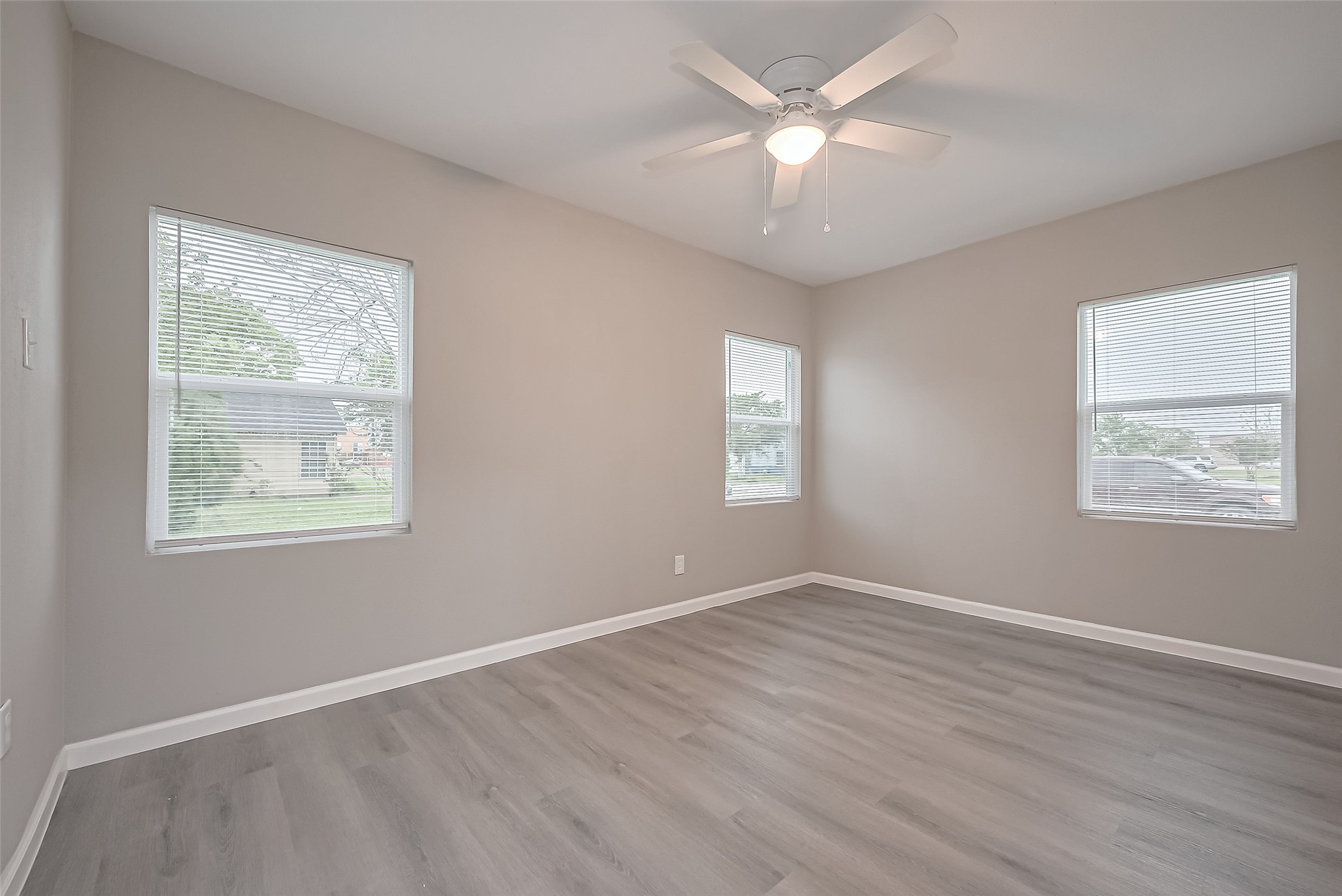 1739-17 West 5th Street Freeport, TX 77541 - Photo 15 of 26 a view of an empty room with a window and wooden floor
