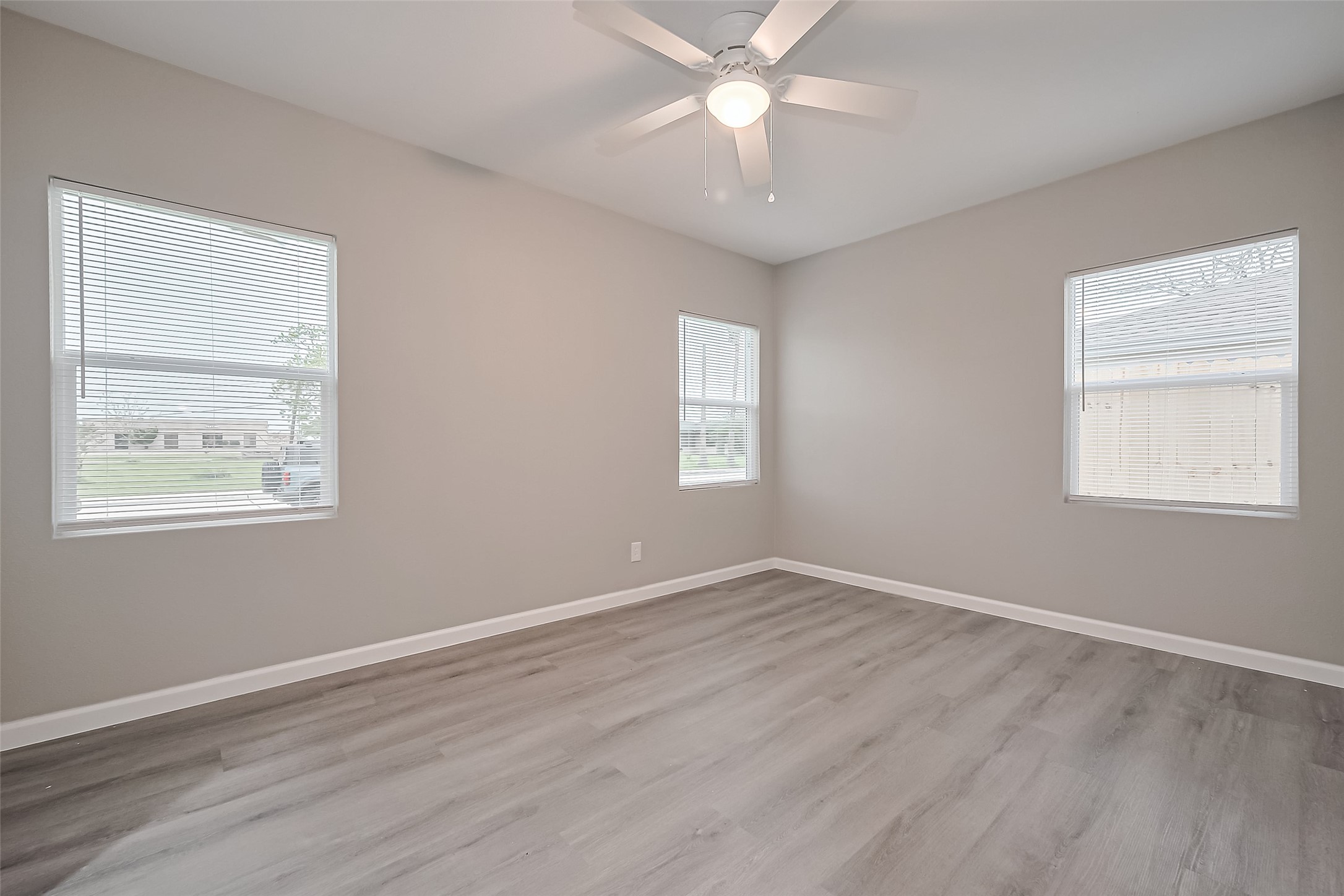 1739-17 West 5th Street Freeport, TX 77541 - Photo 17 of 26 a view of an empty room with a window and wooden floor