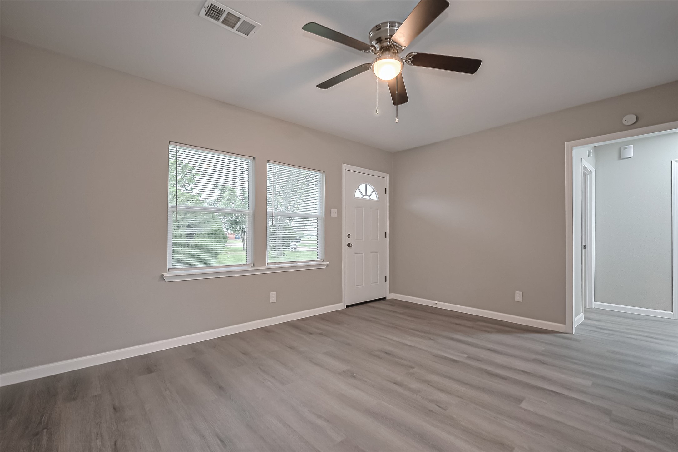 1739-17 West 5th Street Freeport, TX 77541 - Photo 4 of 26 an empty room with wooden floor fan and windows