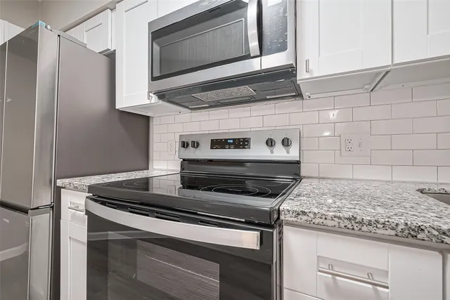 a kitchen with granite countertop cabinets stainless steel appliances and wooden cabinets