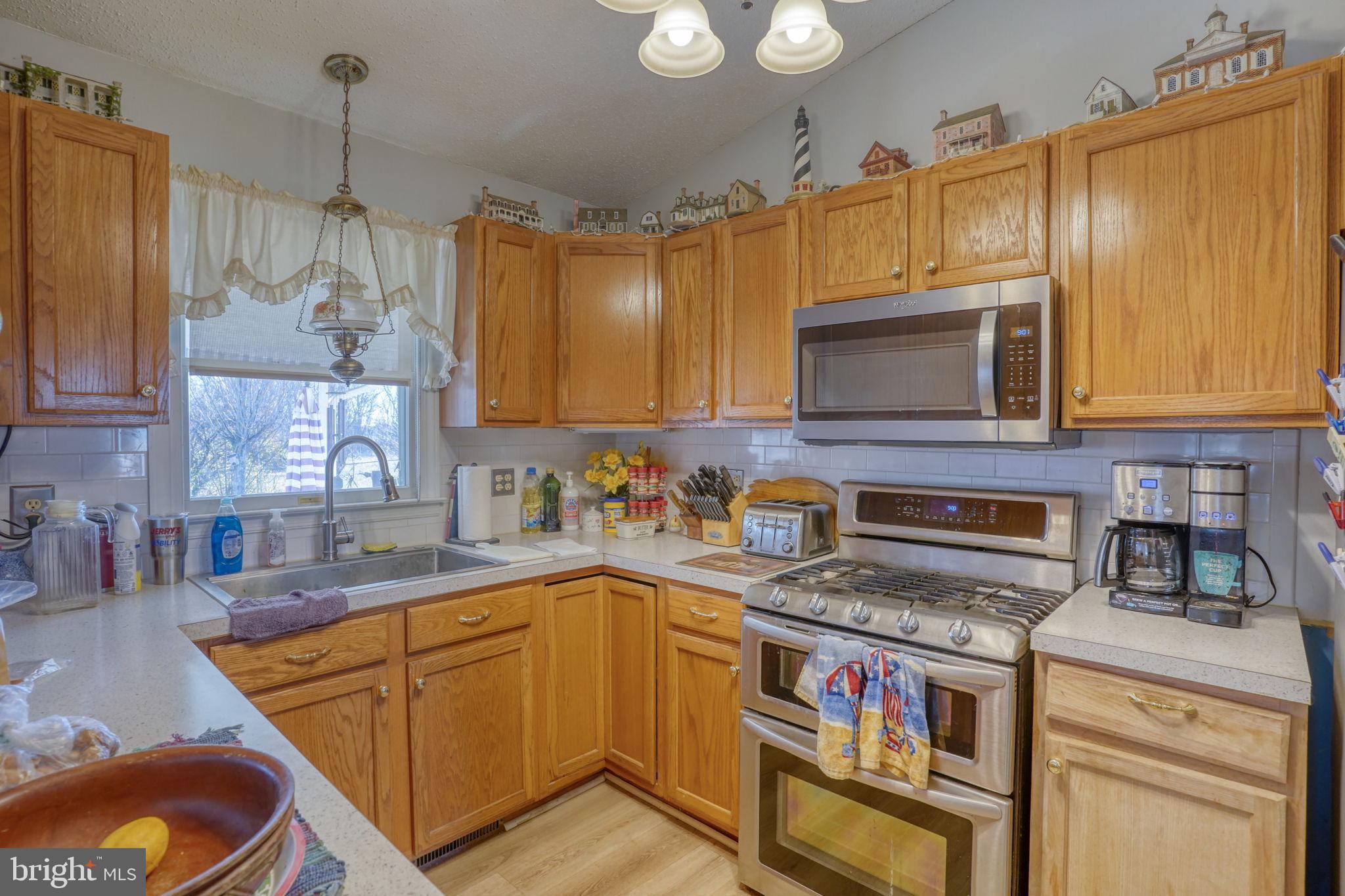 1406 Turkey Point Road Felton, DE 19943 - Photo 13 of 24 a kitchen with stainless steel appliances granite countertop a stove a sink and a microwave