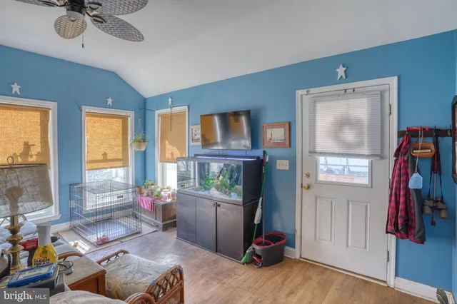 a living room with furniture a flat screen tv and a window