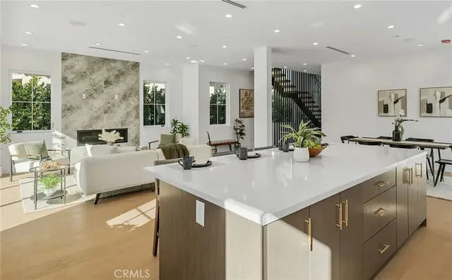 a view of kitchen island with stainless steel appliances a sink and living room view