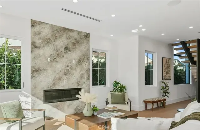 a living room with furniture and potted plants