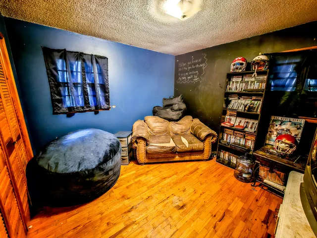 a bedroom with bed and a painting on the wall