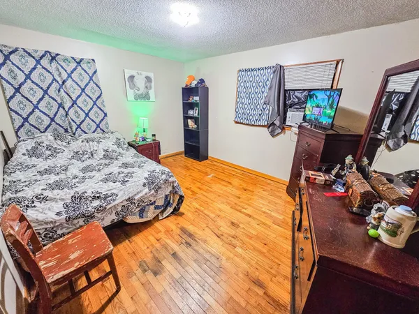 a bedroom with a bed and wooden floor