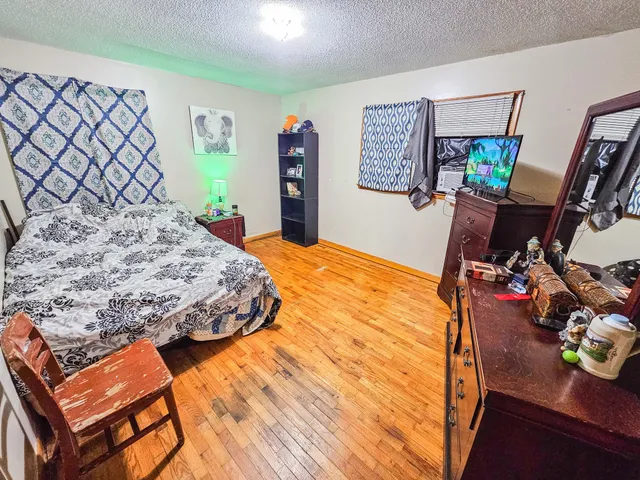 a bedroom with a bed and wooden floor