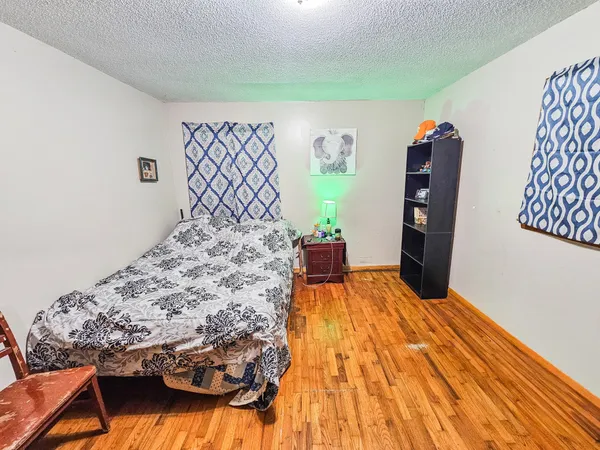 a bed sitting in a bedroom next to a window with potted plant