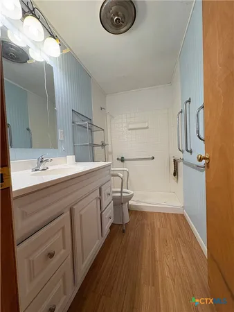 a bathroom with a sink a toilet a mirror and shower