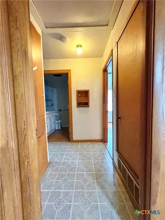 a view of a hallway with wooden shelves