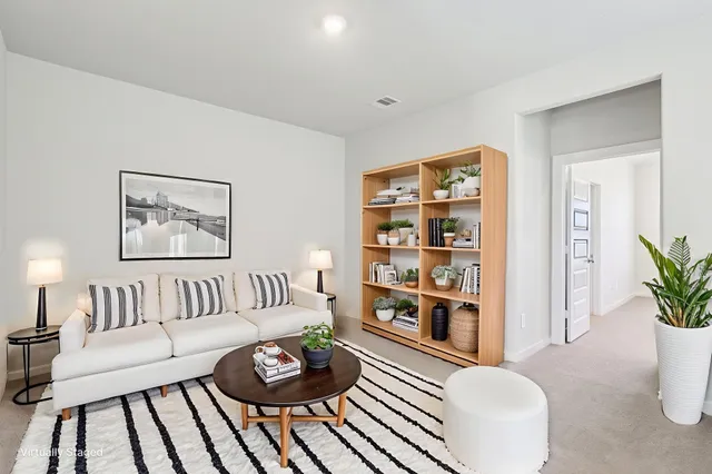 a living room with furniture and a bookshelf with wooden floor