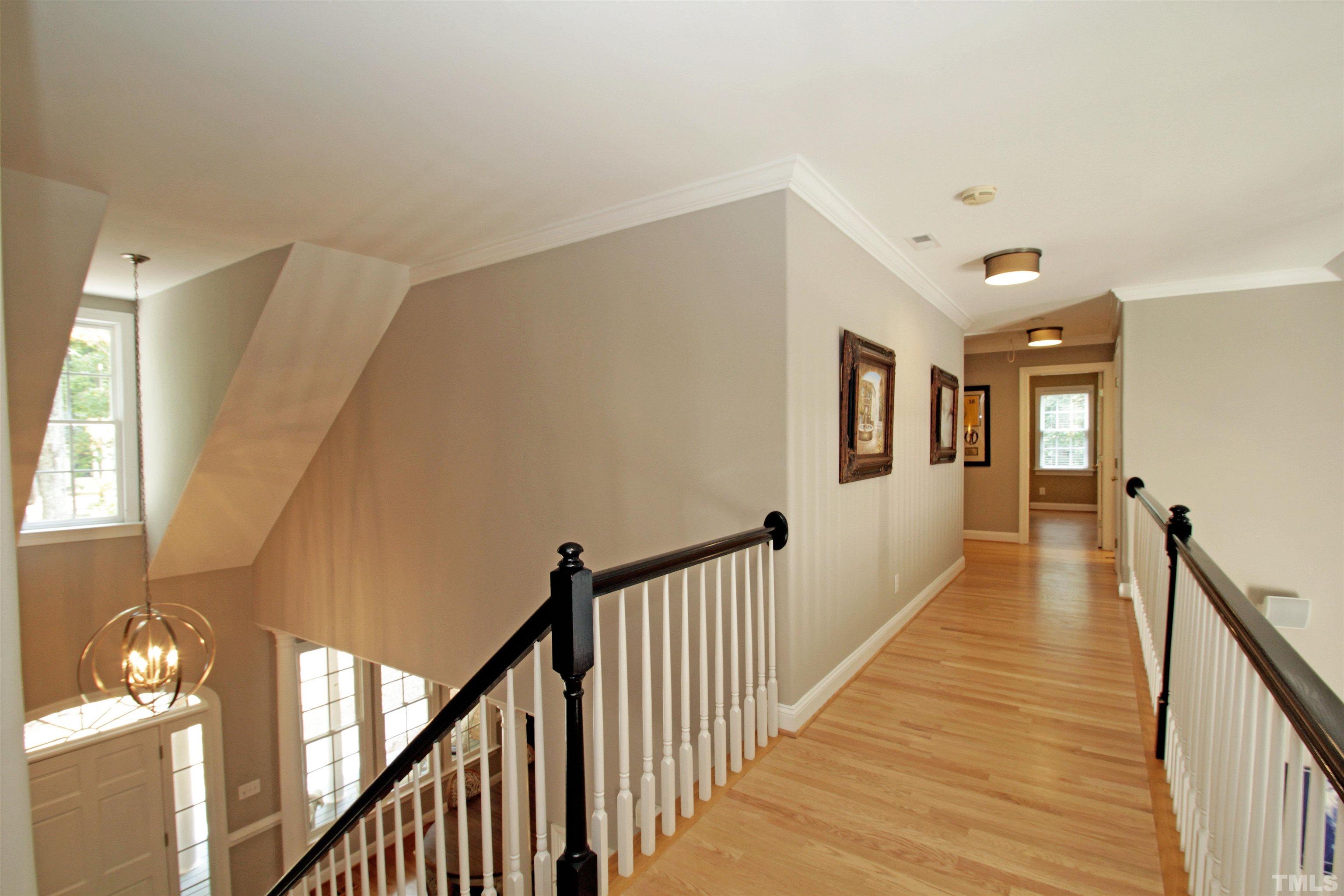11817 Mountbatten Way Raleigh, NC 27613 - Photo 19 of 28 a view of a hallway with wooden floor and stairs
