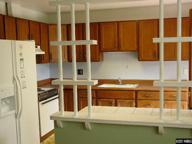 795 Bowman Drive Reno, NV 89503 - Photo 2 of 9 a kitchen with stainless steel appliances granite countertop a refrigerator a stove and a sink with wooden cabinets
