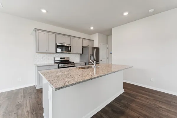 a kitchen with a sink a microwave a stove and refrigerator