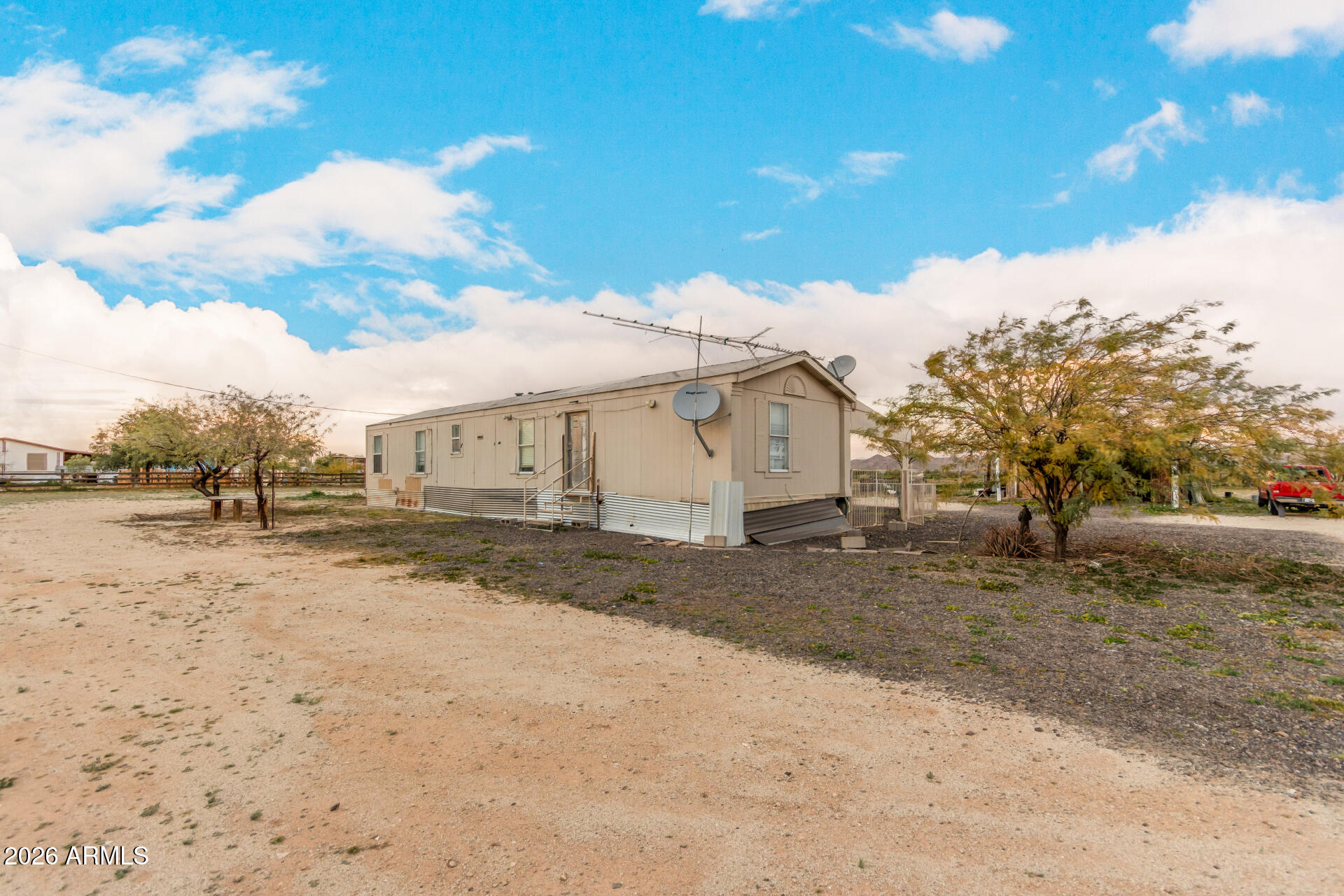 54194 West Organ Pipe Road Maricopa, AZ 85139 - Photo 9 of 52 a view of a dirt yard with a large tree