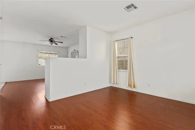 a view of a big room with wooden floor and a ceiling fan