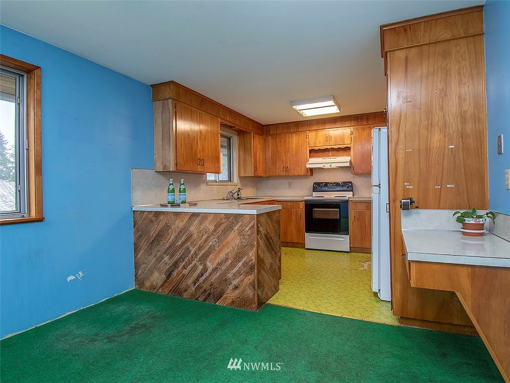 17371 Southeast 133rd Street Renton, WA 98059 - Photo 5 of 22 a kitchen with kitchen island granite countertop wooden cabinets and stainless steel appliances