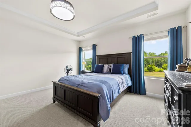 a bedroom with a bed lamp and a large window